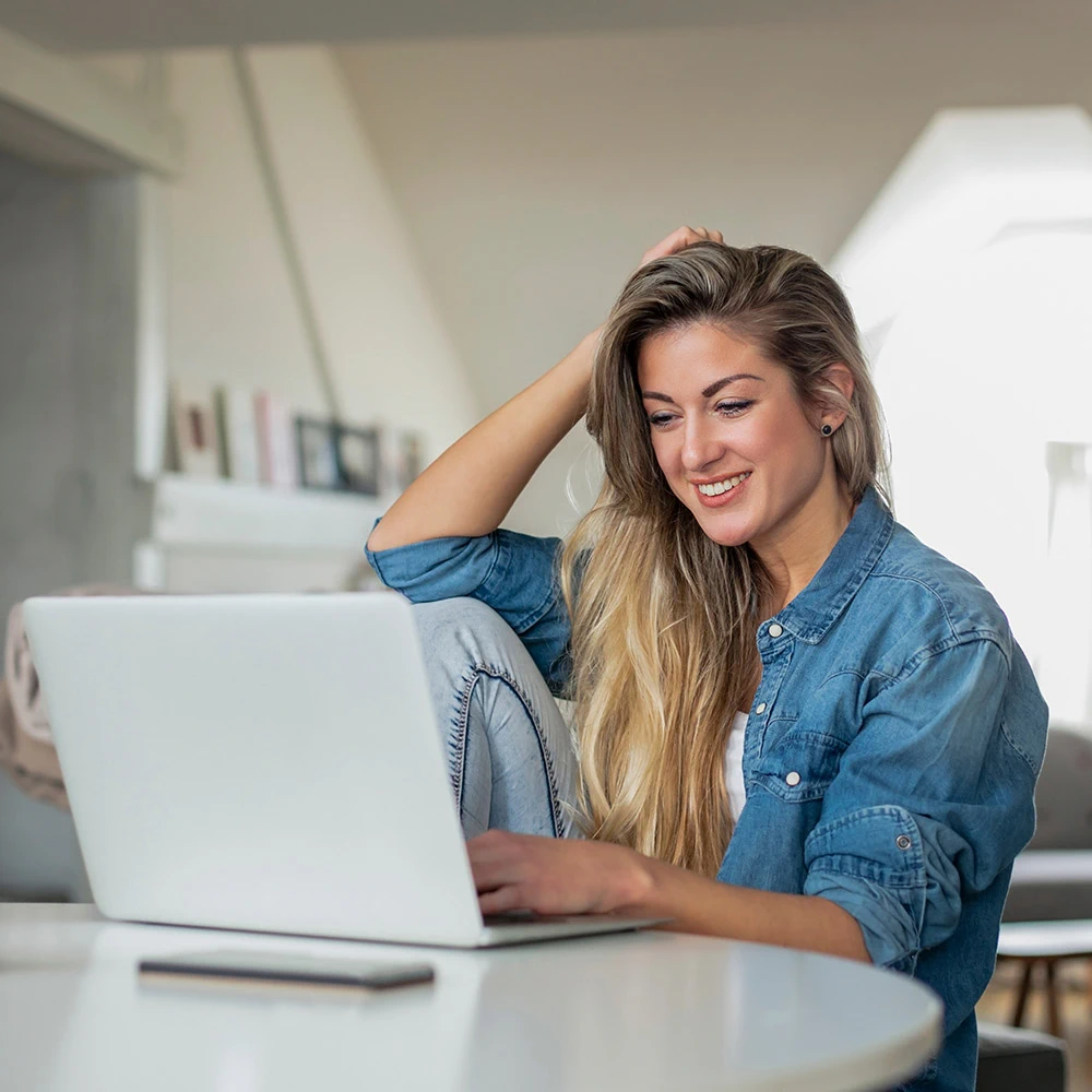 Vrouw aan tafel achter haar laptop