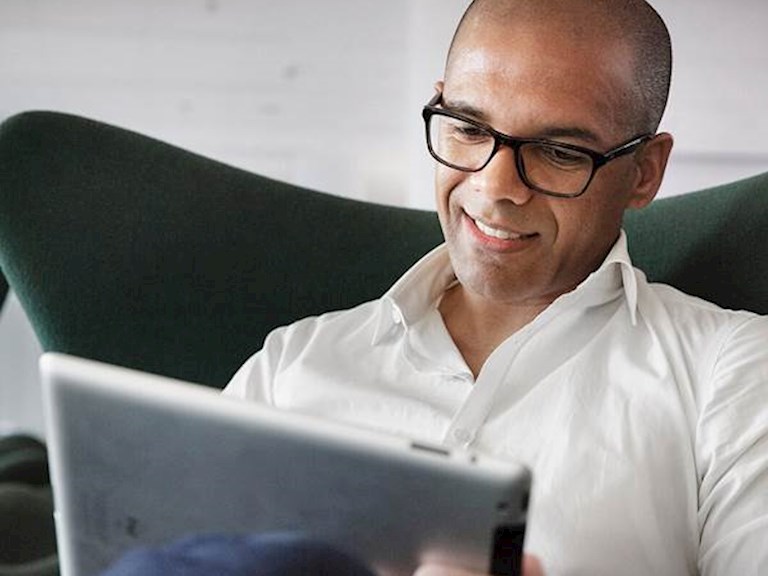 man met tablet op de bank