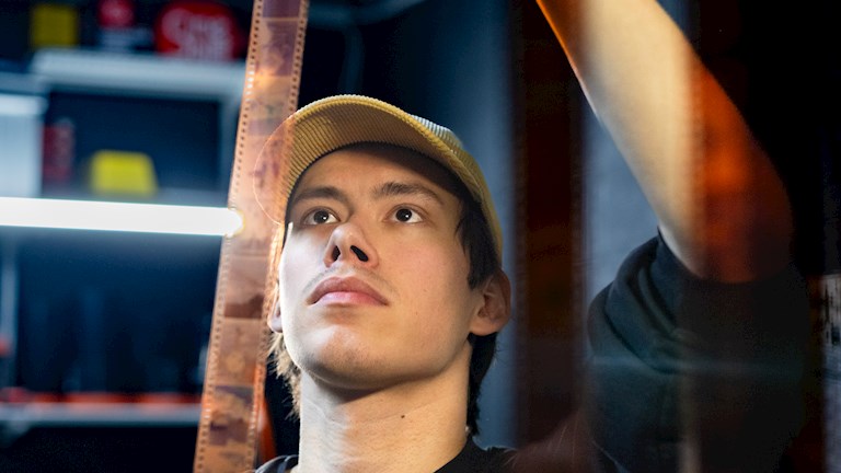 ondernemer bekijkt negatieven in donkere kamer