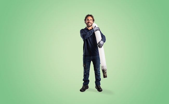 Man met inblaasmachine staat klaar om bodemisolatie te plaatsen.
