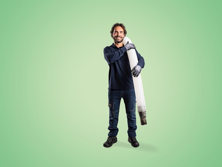 Man met inblaasmachine staat klaar om bodemisolatie te plaatsen.