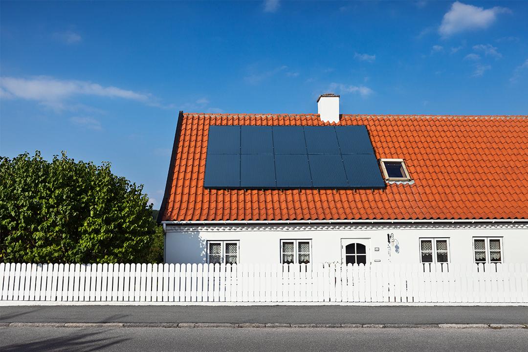 Huis met rood dak met zonnepanelen