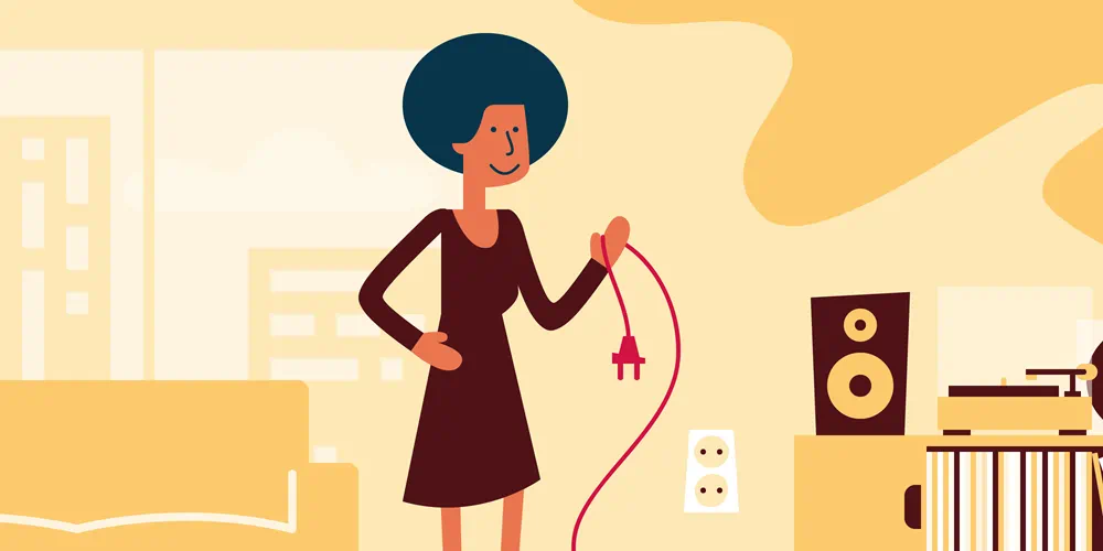 Een vrouw bespaart energie door de stekker uit het stopcontact te halen