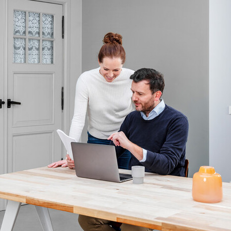 Koppel bekijkt energierekening achter de laptop