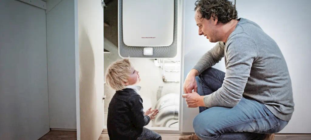 Vader en zoon zitten naast cv-ketel