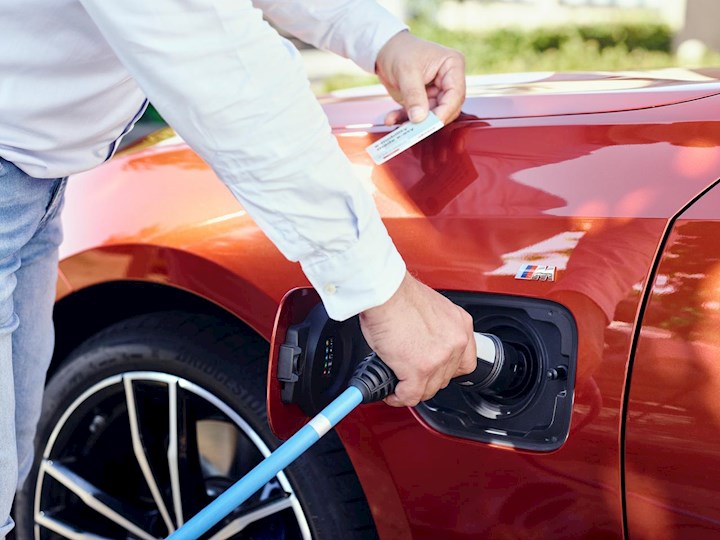Man met stekker bij elektrische auto | Eneco