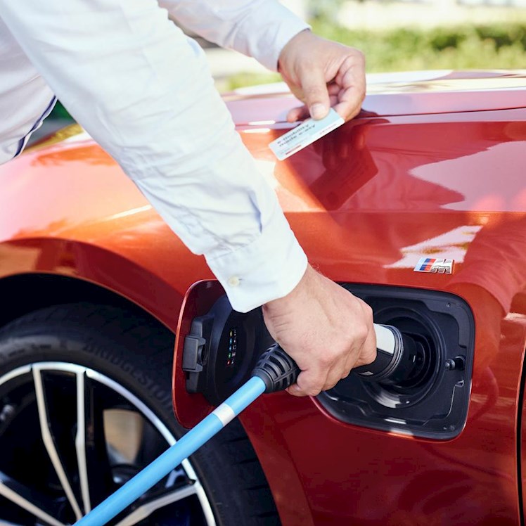 Man met stekker bij elektrische auto | Eneco