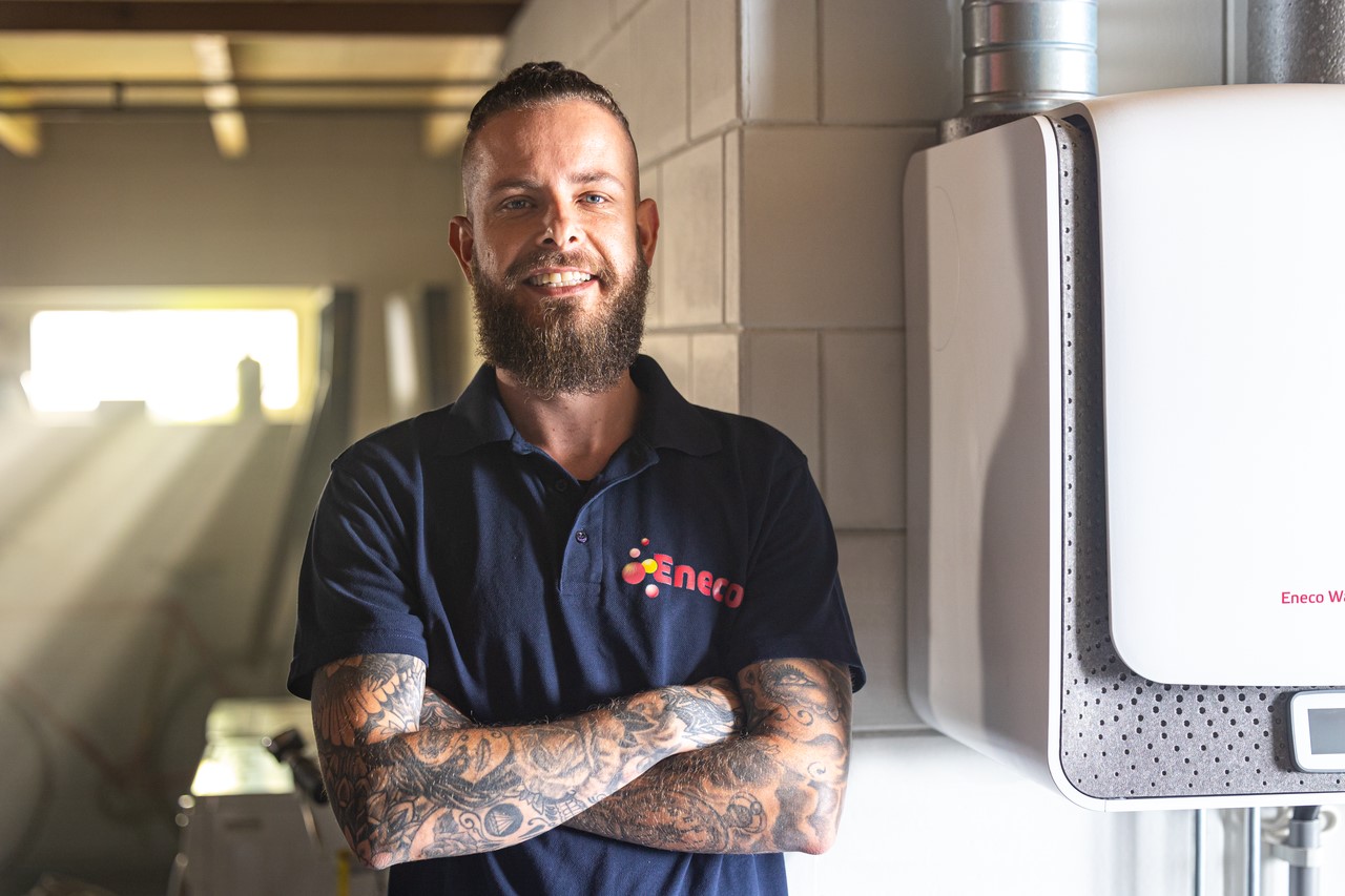 Vrolijke eneco monteur staat bij een warmtepomp