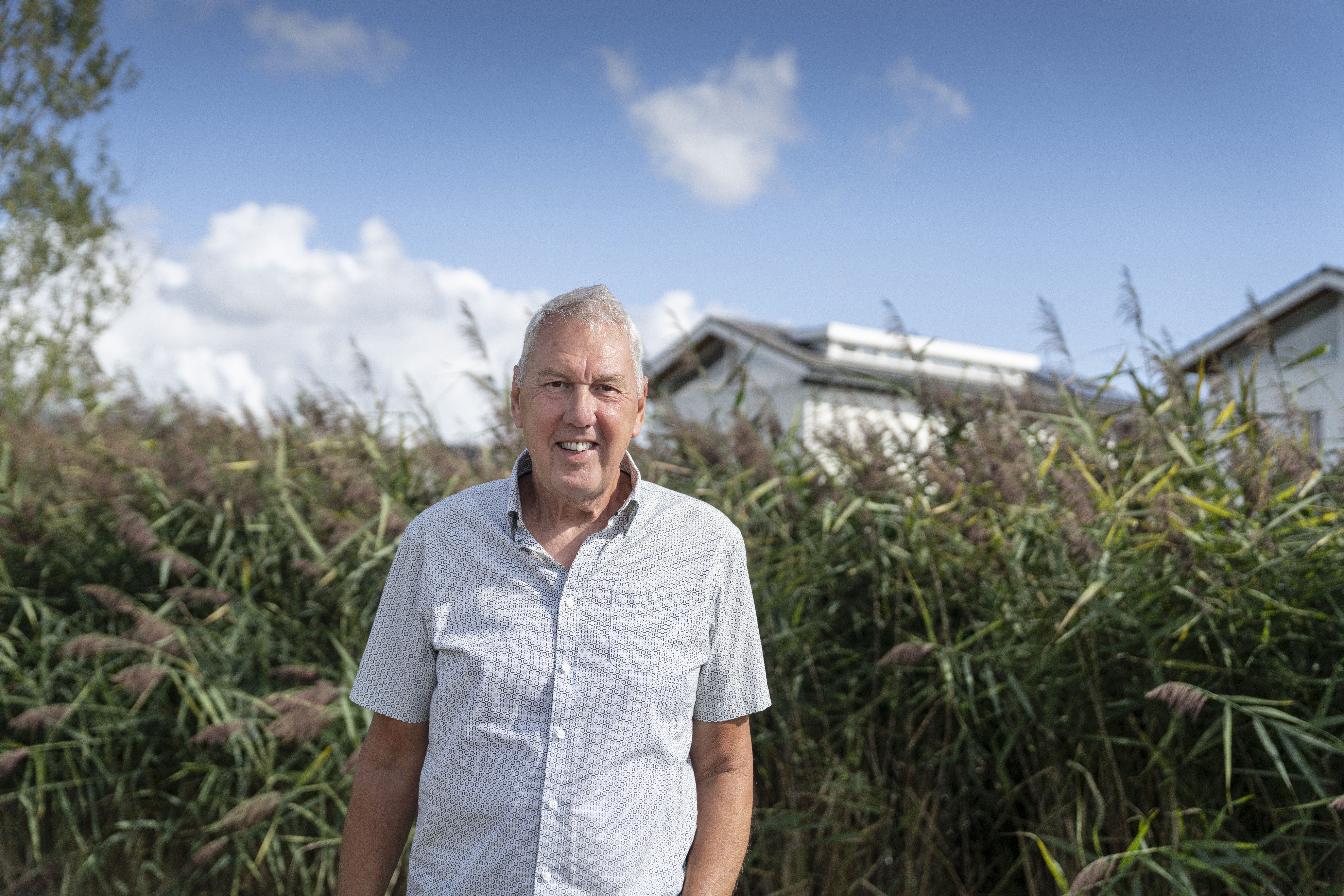 Een Eneco-klant staat voor zijn huis met zonnepanelen