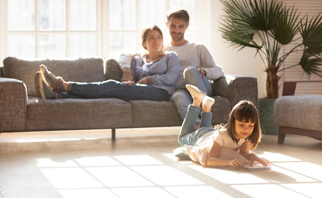 Warme huiskamer met meisje dat op de grond speelt in een goed geïsoleerd huis"