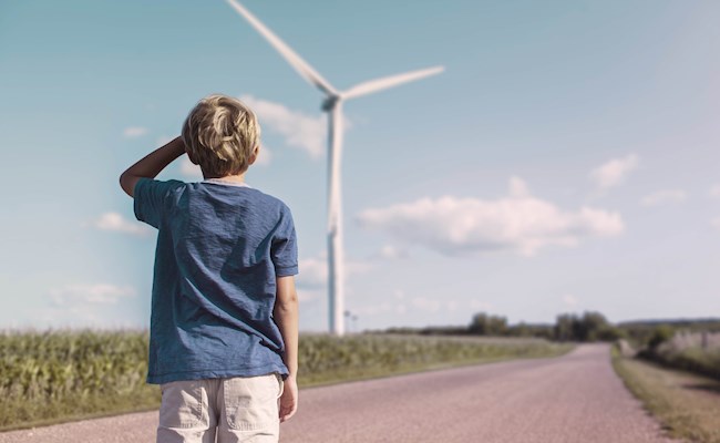 Verwachting energietarieven, jongen kijkt naar windmolen