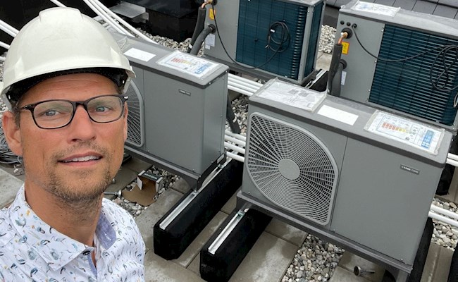 Eneco Innovatie & technology manager Gijs met helm op staat bij een warmtepomp