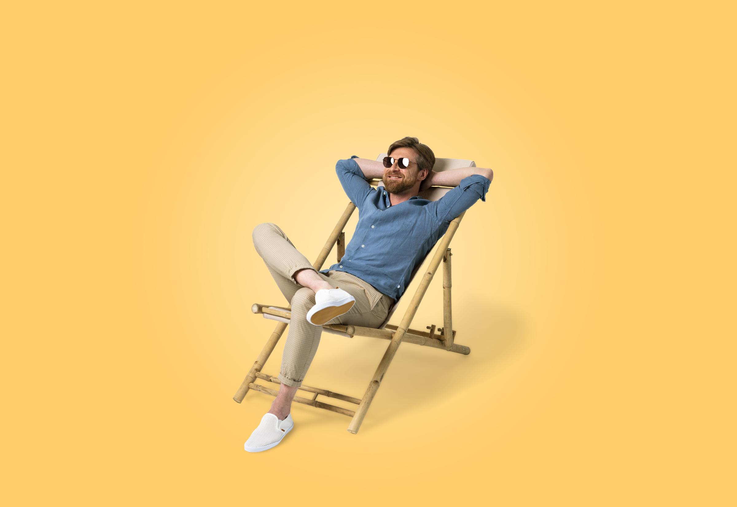 Man zit in een comfortabele stoel te genieten van de zon.