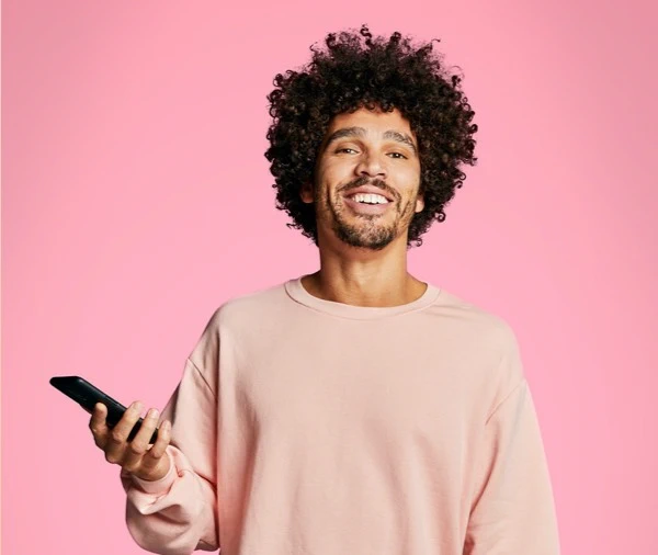 Man met smartphone in hand op roze achtergrond