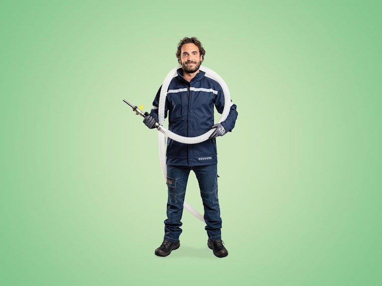 Monteur met inblaasmachine staat klaar om spouwmuurisolatie te plaatsen.