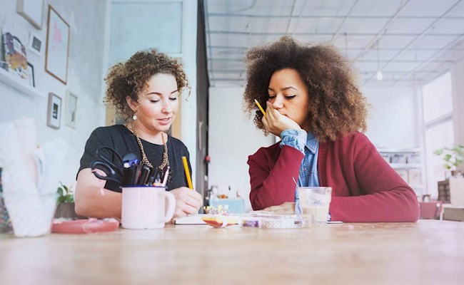 Twee vrouwen zitten samen aan een tafel