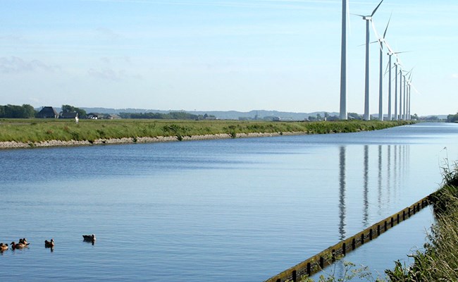 Hollands beeld van kanaal met windmolens op de achtergrond
