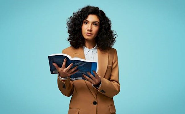 Vrouw met wetboek in haar handen voor een blauwe achtergrond