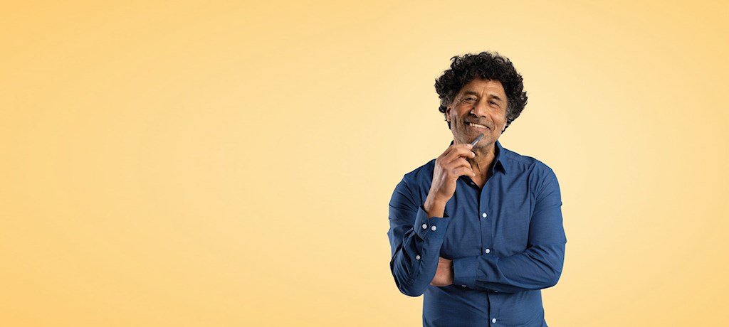 Een lachende man houdt een pen vast