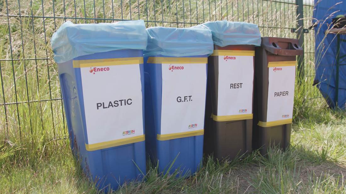 Een rij met afvalbakken voor gescheiden afval