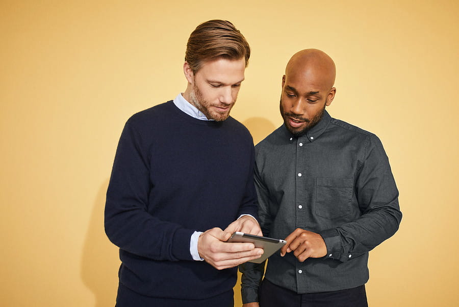 Twee heren kijken samen op een tablet